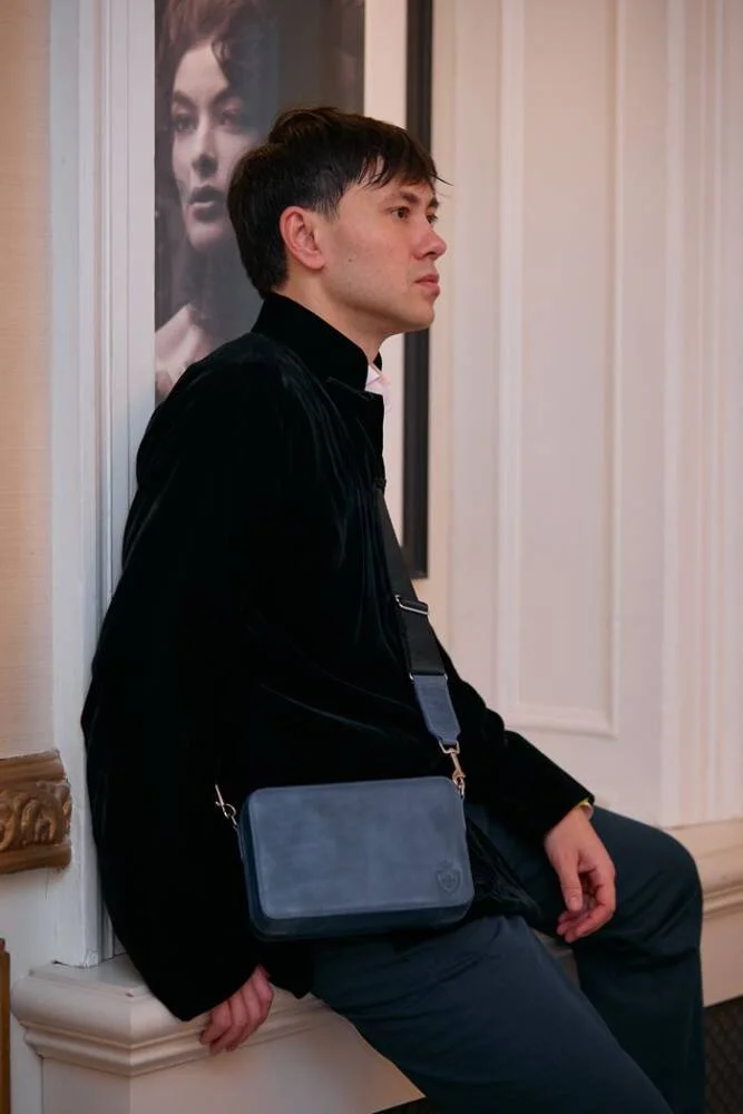 "Man in a sleek suit carrying the Aficionado Elegance Italian leather crossbody bag.