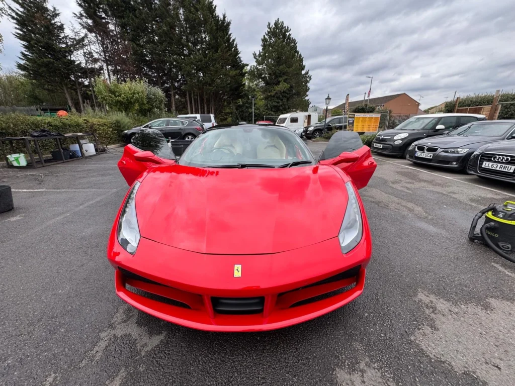 Red Ferrari sports car front view with doors open