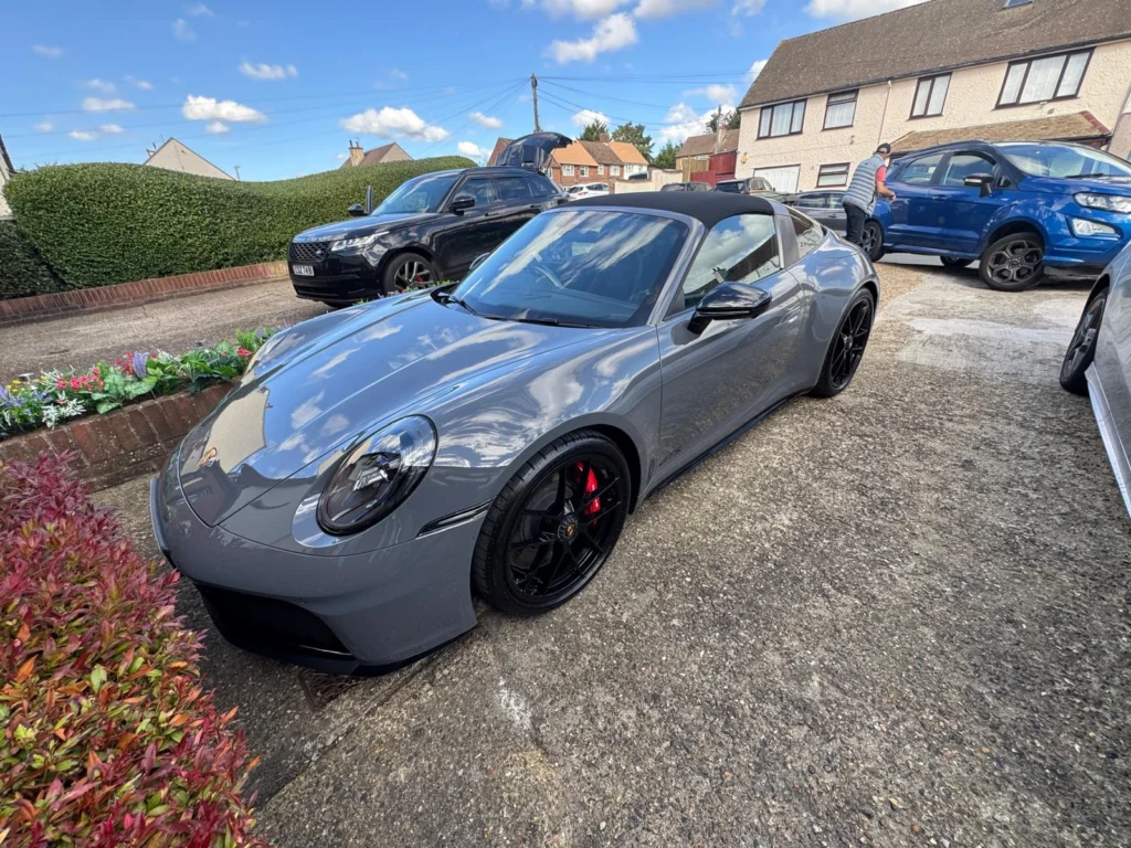 Grey Porsche 911 sports car parked in residential driveway